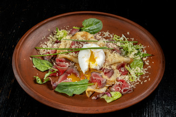 Diet menu. Salad with chopped steak, poached eggs, pancakes, green salad. Sprinkled with grated cheese.
