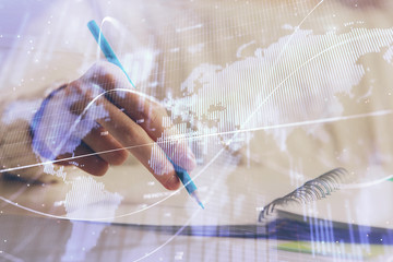Financial forex graph displayed on hands taking notes background. Concept of research. Double exposure