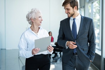 Senior mature caucasian female executive ceo discuss report with young colleague