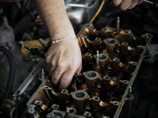 Auto mechanic working in garage. Remove the cover part. Authentic close-up