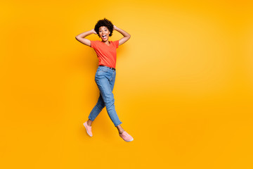 Fototapeta na wymiar Full length photo of funny funky crazy girl have walk jump go feel cheerful have weekends free time in spring wear red stylish clothes sneakers isolated over yellow color background
