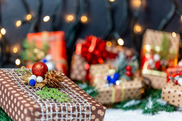 Christmas presents with branches Christmas tree on a snow. Christmas gifts on bokeh background