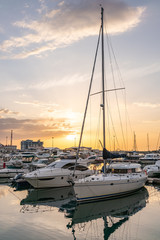 Yellow sunset in the sea harbor with moored yachts.