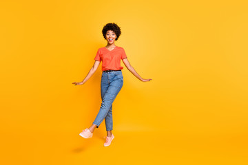 Fototapeta na wymiar Full length body size photo of charming cute cheerful crazy funny black girlfriend wearing jeans denim t-shirt footwear approaching you while isolated over yellow vivid color background