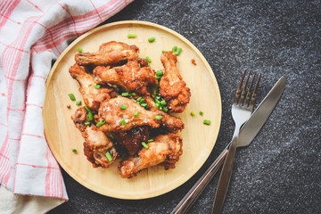 Fried chicken wings crispy salt on wooden plate with fork knife in the dining table - Baked chicken wings barbecue