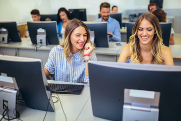 College students sitting in a classroom, using computers during class.