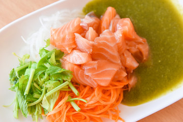 Salmon salad menu set Japanese cuisine fresh ingredients on plate - Japanese food raw sashimi salmon fillet with carrot celery seafood sauce in the restaurant