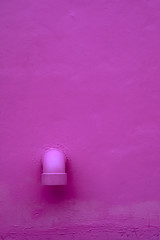 Pink concrete with drainage pipe for background.