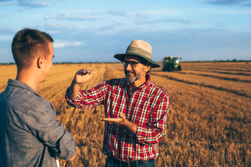 two ranchers talking outdoor on wheat field