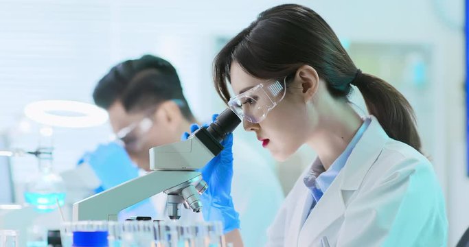Asian scientist use microscope