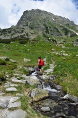Fototapeta na wymiar A girl with a backpack hiking in the polish mountains