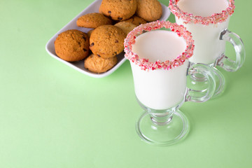 Two glasses of eggnog on green background. Traditional Christmas beverage.