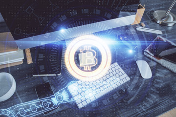 Double exposure of blockchain and crypto economy theme hologram and table with computer background....