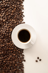 Contrasted coffee beans background and cup