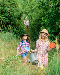 Think green. small girls farmer in village. children hold gardening tools. earth day. summer family farm. farming and agriculture. spring country side. ecology and environmental protection