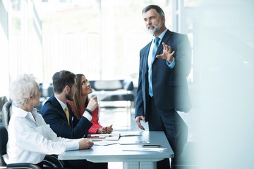 Businesspeople discussing together in conference room during meeting at office.