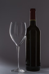 Bottle of red wine with a glass