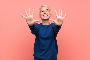 Teenager girl with white short hair over pink wall counting ten with fingers