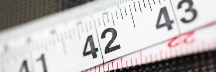 Focus on device lying on table covered in black textile. Stripes with printed numerals used to...