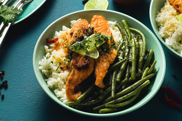 fresh salmon fried with ginger and garlic in coconut milk, with basmati rice and green beans in plates on the table. healthy recipe for the whole family.