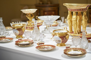 Wedding. Banquet. The chairs and round table for guests, served with cutlery, greenery flowers and crockery and covered with a white tablecloth