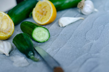 cucumber, lemon and garlic on concrete ground
