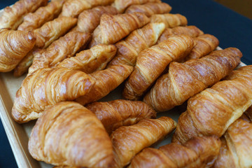 Lots of traditional croissants on the counter. Classic breakfast.