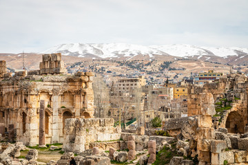 Fototapeta na wymiar Ancient ruins of Grand Court of Jupiter temple, with modern lebanese houses in the background, Beqaa Valley, Baalbeck, Lebanon
