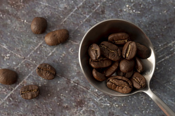Coffee beans on spoon with marble background