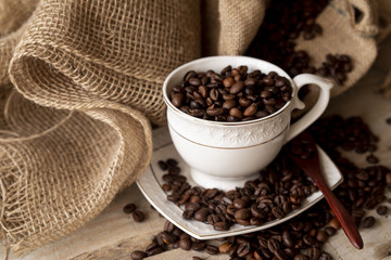 High view cup of coffee beans and burlap sack