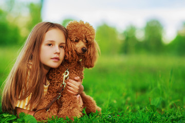 Little girl with a brown poodle dog
