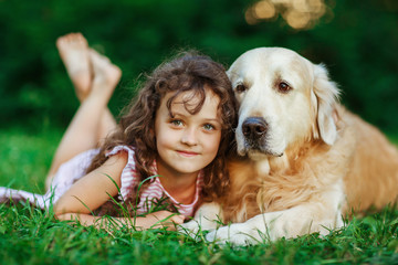 Little girl with a golden retriever, outdoor summer