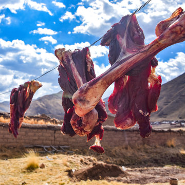 Alpaca meat and bones hang to dry on a washing line in rural Cusco, Peru