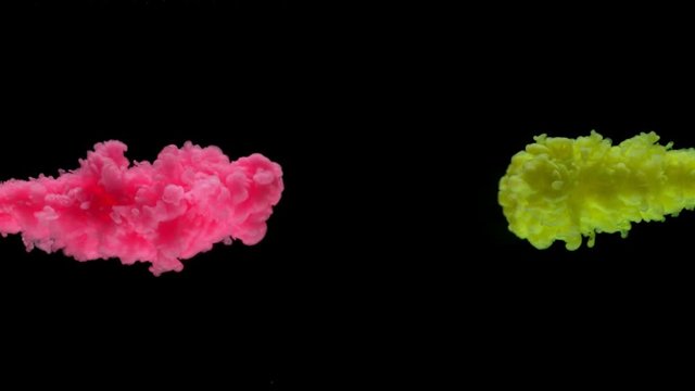 Super slow motion of coloured inks in water. Isolated on black background. Filmed on high speed cinema camera.