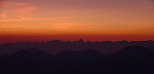 Colorful morning sky spans above the endless rocky Julian alps at scenic dawn.