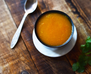 pumpkin cream soup in a plate on a wooden table