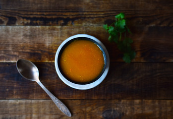pumpkin cream soup in a plate on a wooden table
