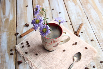 Obraz na płótnie Canvas bouquet of flowers in a cup of coffee on wooden background as a symbol of renovating