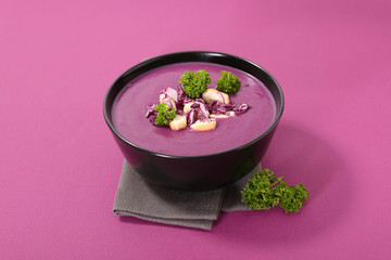 Obraz na płótnie Canvas red cabbage soup with crouton on pink background