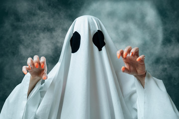 White ghost with spooky gesture in Halloween full moon night.