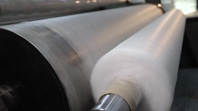 Pliester manufacturing process. Roll-up of non-woven fabric in a factory