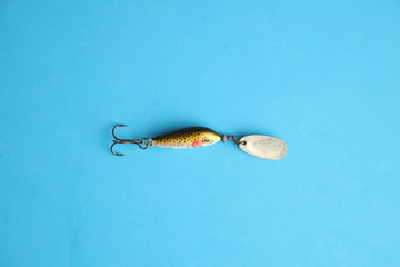 fish-shaped fishing lure on color background