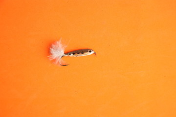 fish-shaped fishing lure on color background