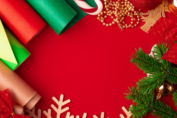 Close up shot of wrapping paper and items for christmas decorating on red background