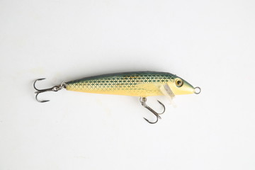 fish-shaped fishing lure on color background