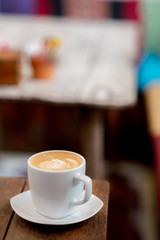 A cup of cafe late art on wooden table with blur backgroud for copy space.