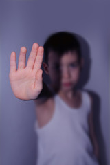 boy in a white T-shirt stands, closes his palm, protest concept, close-up, blue tint to convey drama