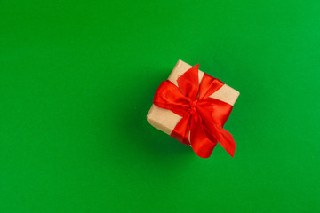 Decorated gift box on a green background, flat lay top view