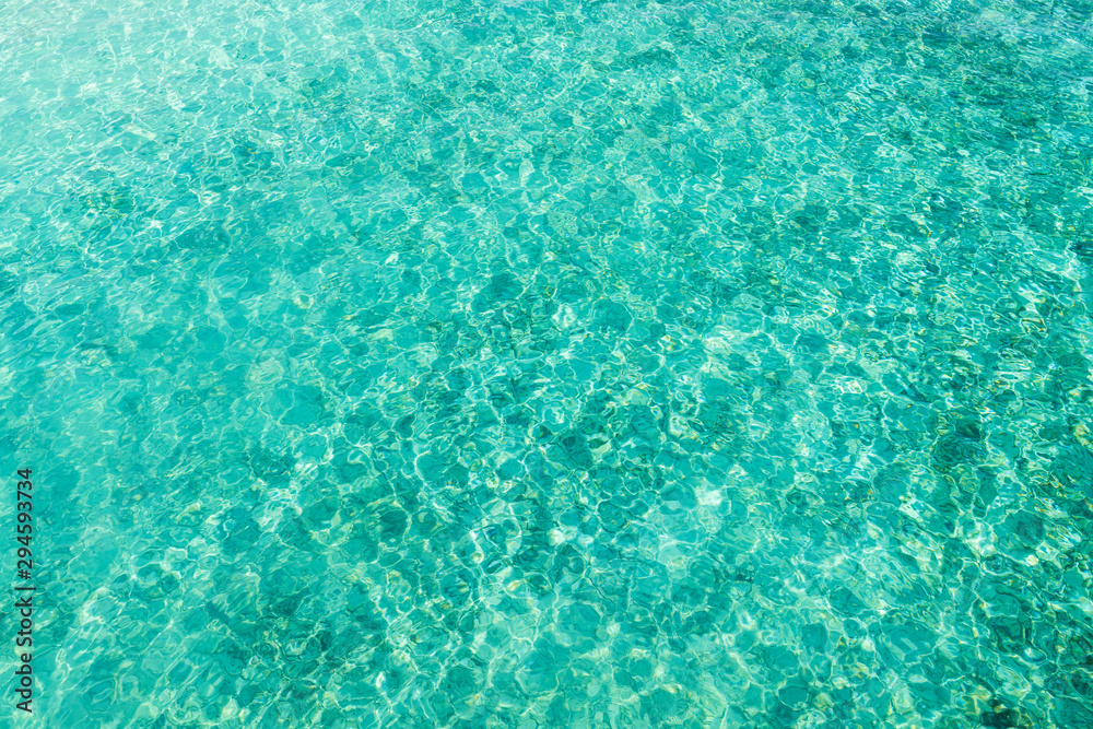 Wall mural top view of ripple surface of crystal clear sea with sun reflection. concept for texture background 