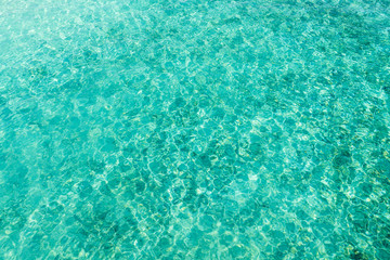 Top view of ripple surface of crystal clear sea with sun reflection. Concept for texture background or wallpaper.